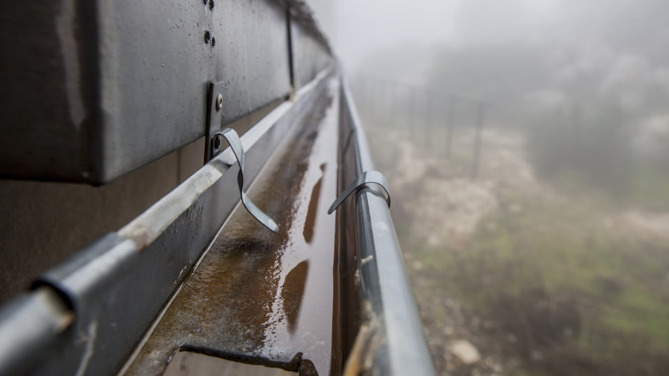 Gutter drainage system on the roof with dripping fog